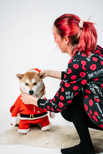 mujer acomodando al ropa navidena del perrito