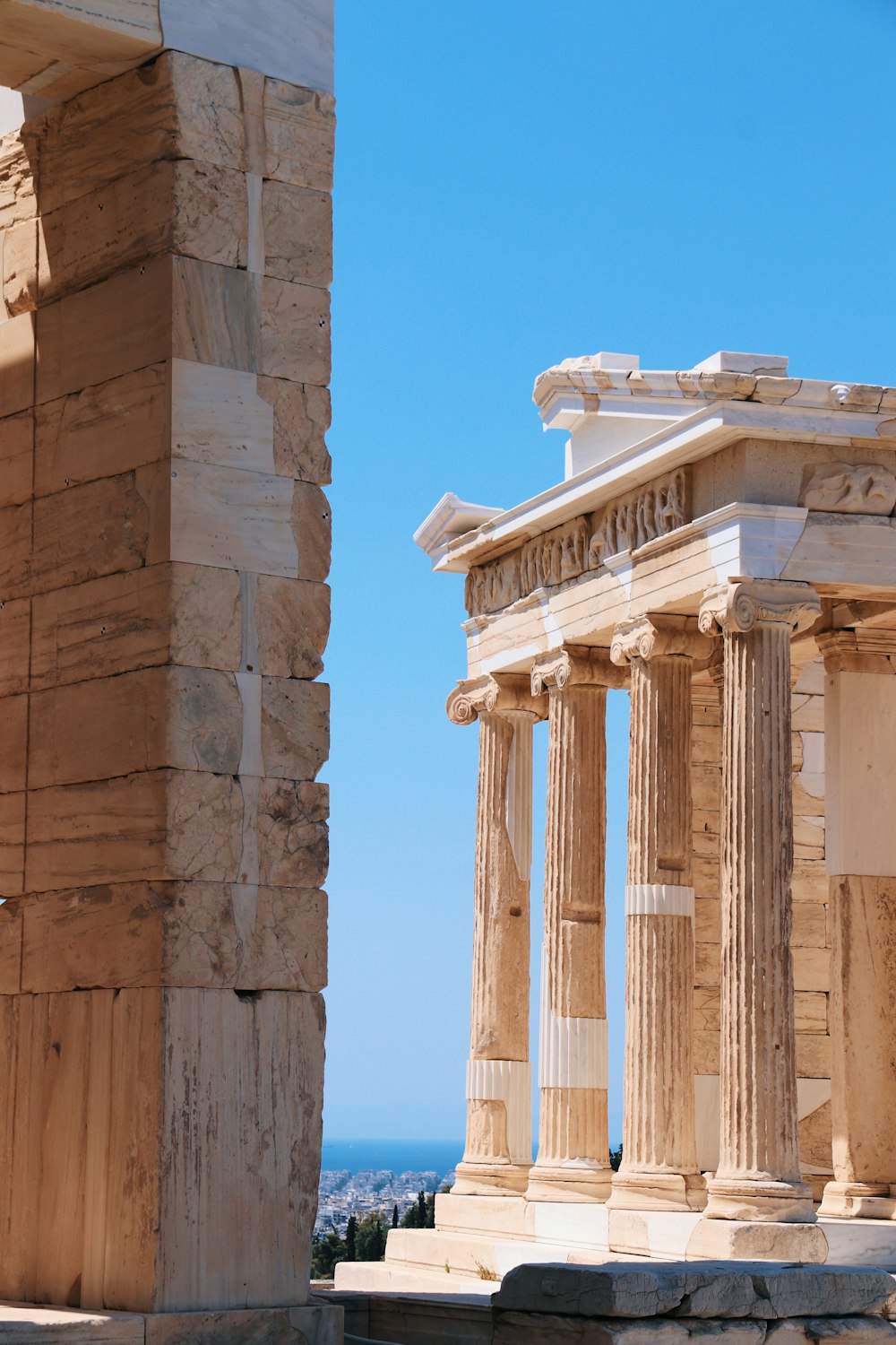 a stone building with columns and a blue sky in the background