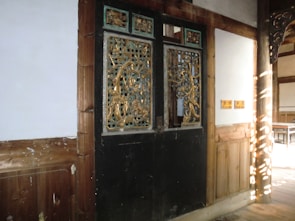 A sturdy wooden door with intricate carvings, bathed in warm sunlight.