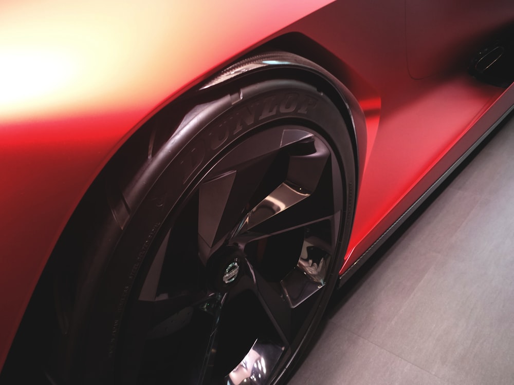 a close up of a red sports car tire