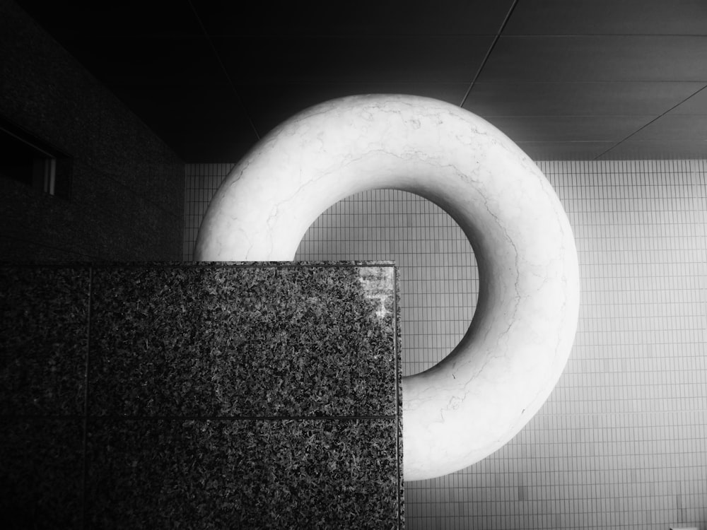 a black and white photo of a circular object in a bathroom