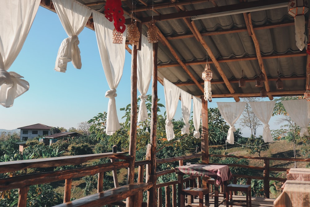 a covered porch with a table and chairs