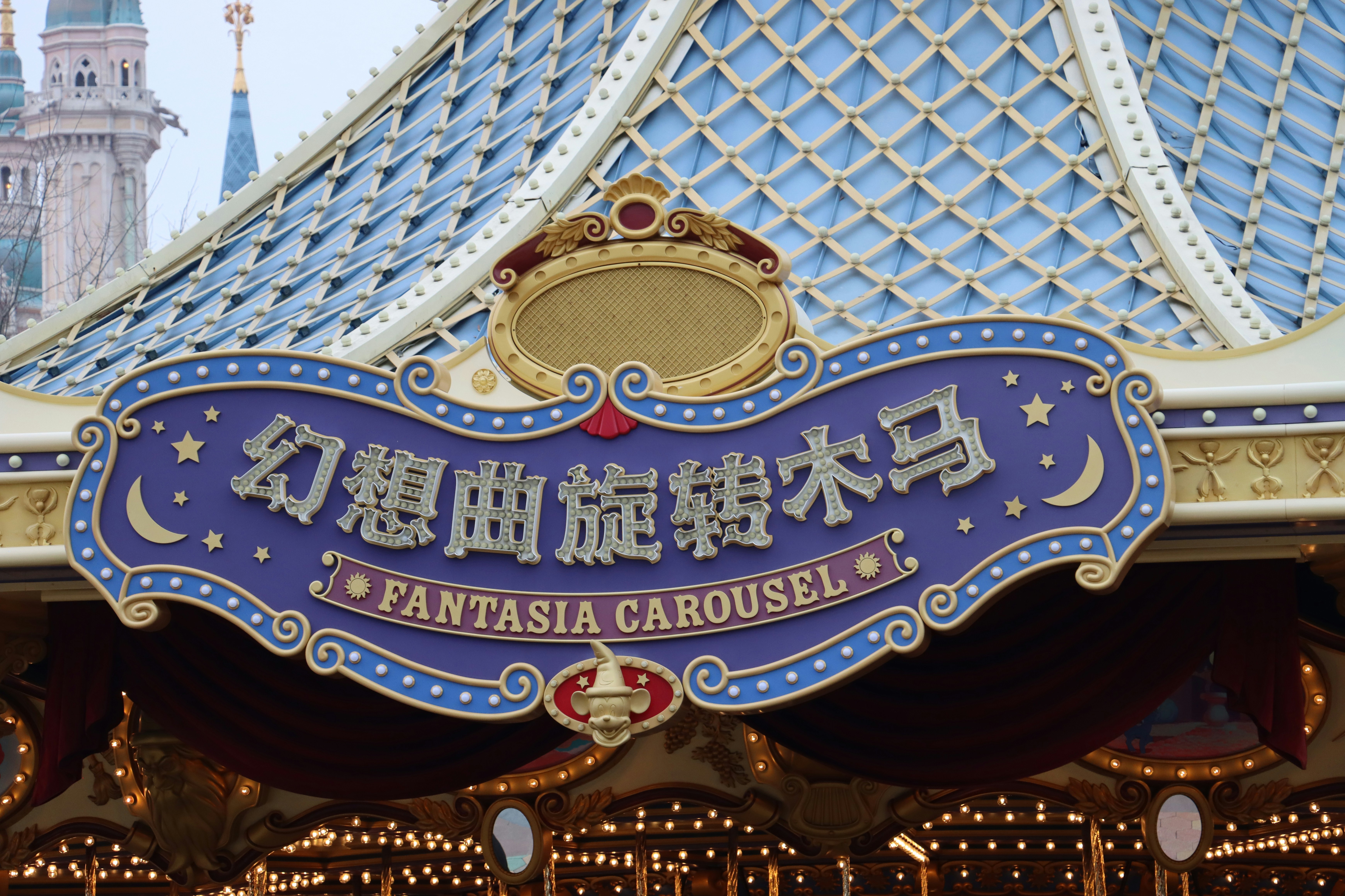 a sign for a carnival with a castle in the background