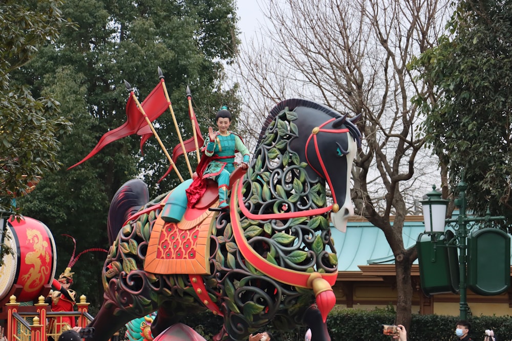 a woman riding on the back of a decorated elephant