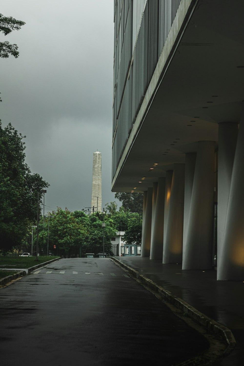 an empty street with a tall building in the background