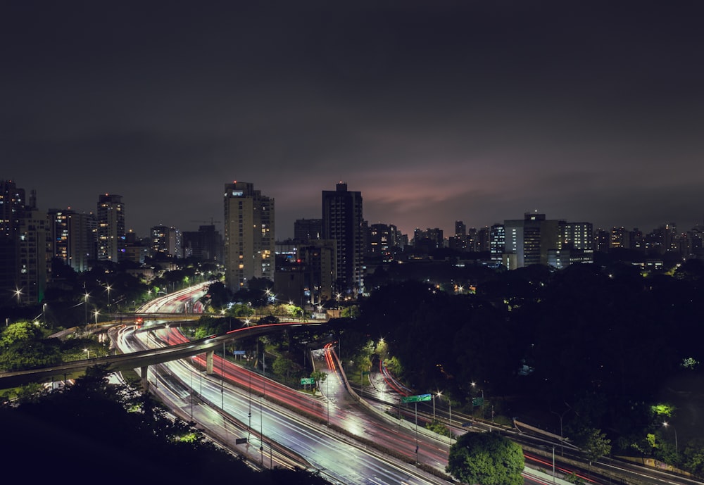 a city skyline at night with a long exposure of traffic