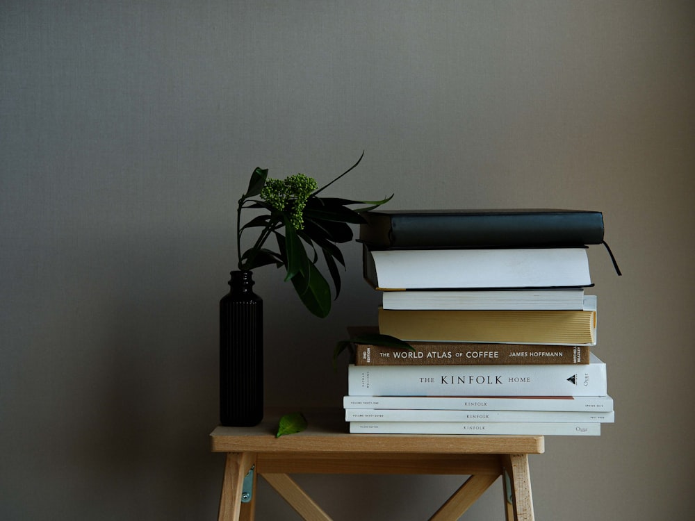 a stack of books sitting on top of a wooden table