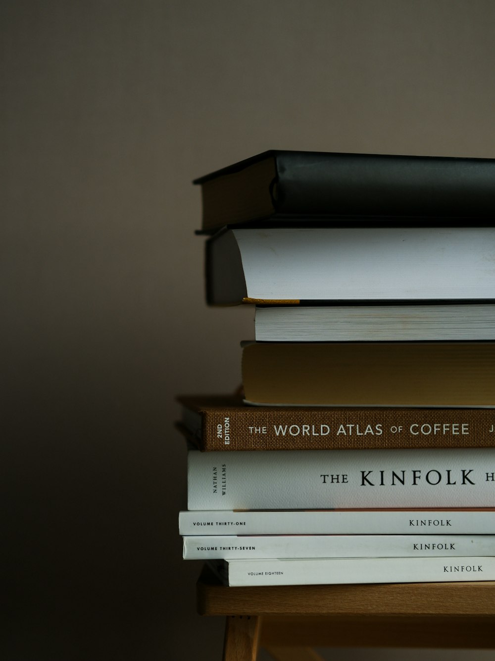 a stack of books sitting on top of a wooden table