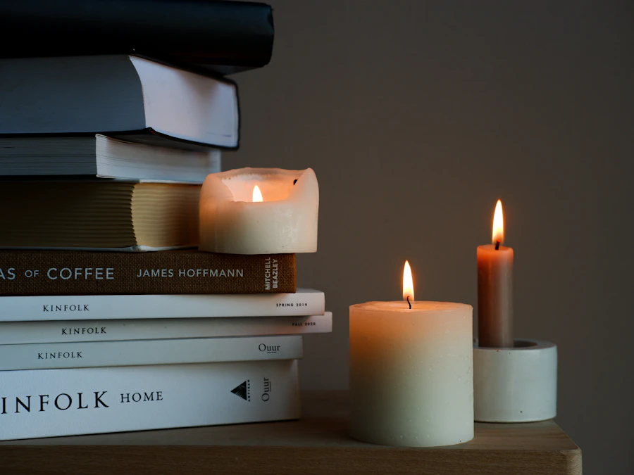 A stack of books beside a lit candle