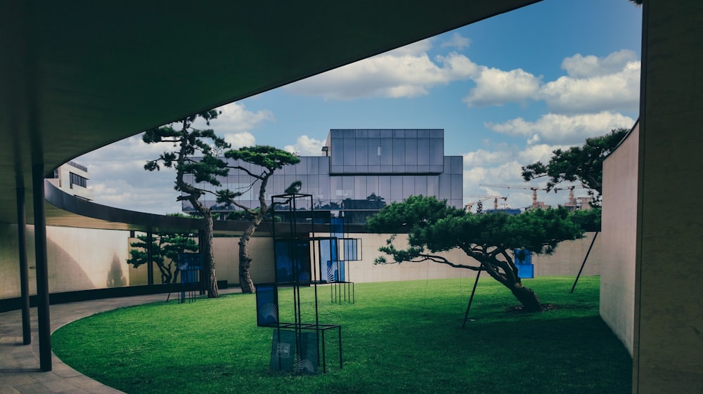 a grassy area with trees and a building in the background