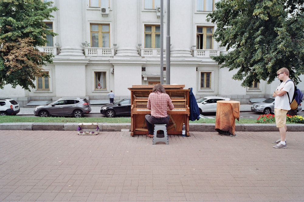 a man sitting on a bench next to a piano