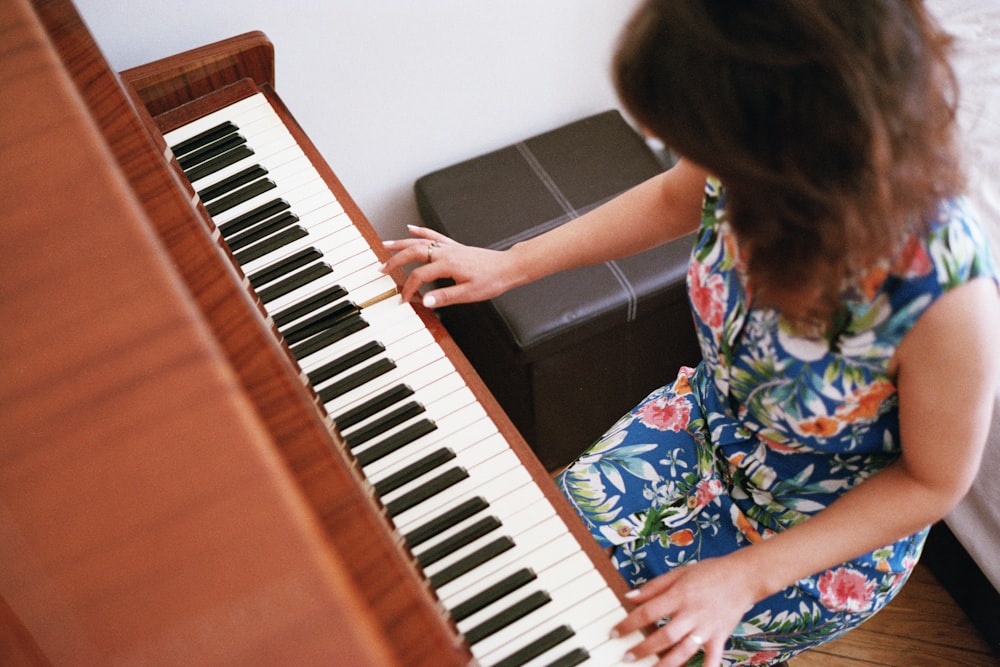 a young girl playing a piano in a living room