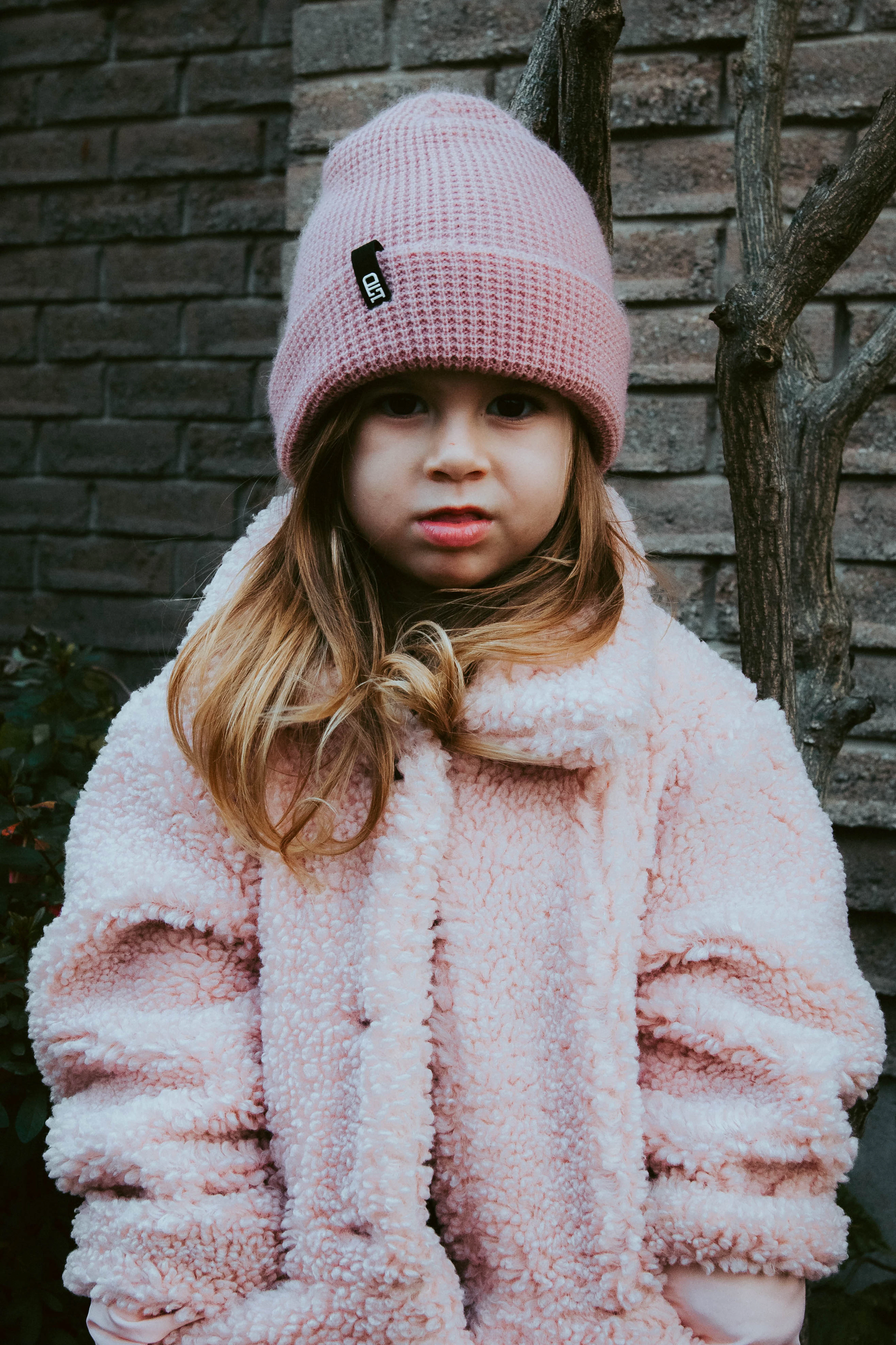 A girl in a pink beanie and soft fleece jacket