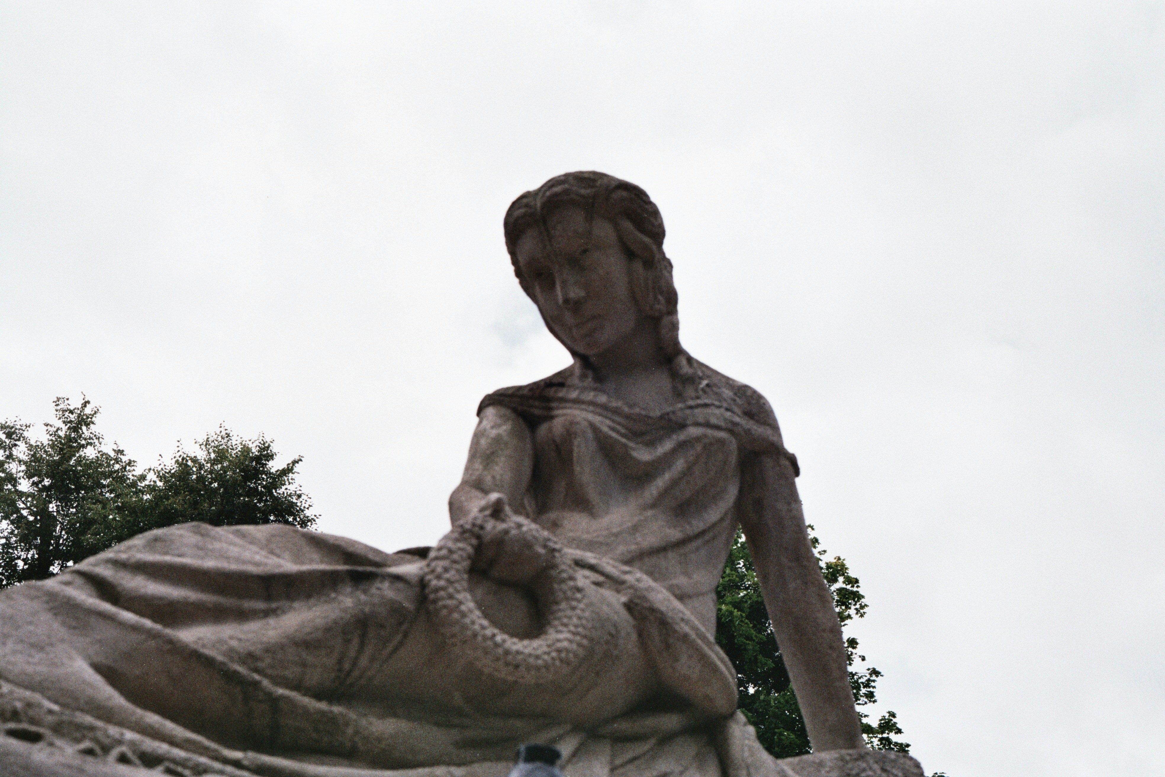 a statue of a woman sitting on a rock