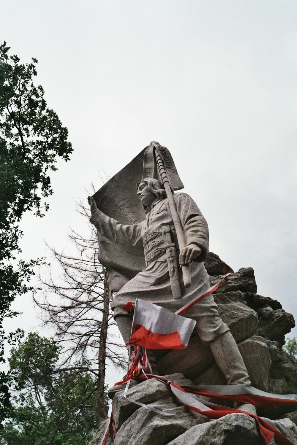 a statue of a man holding a flag on top of a rock