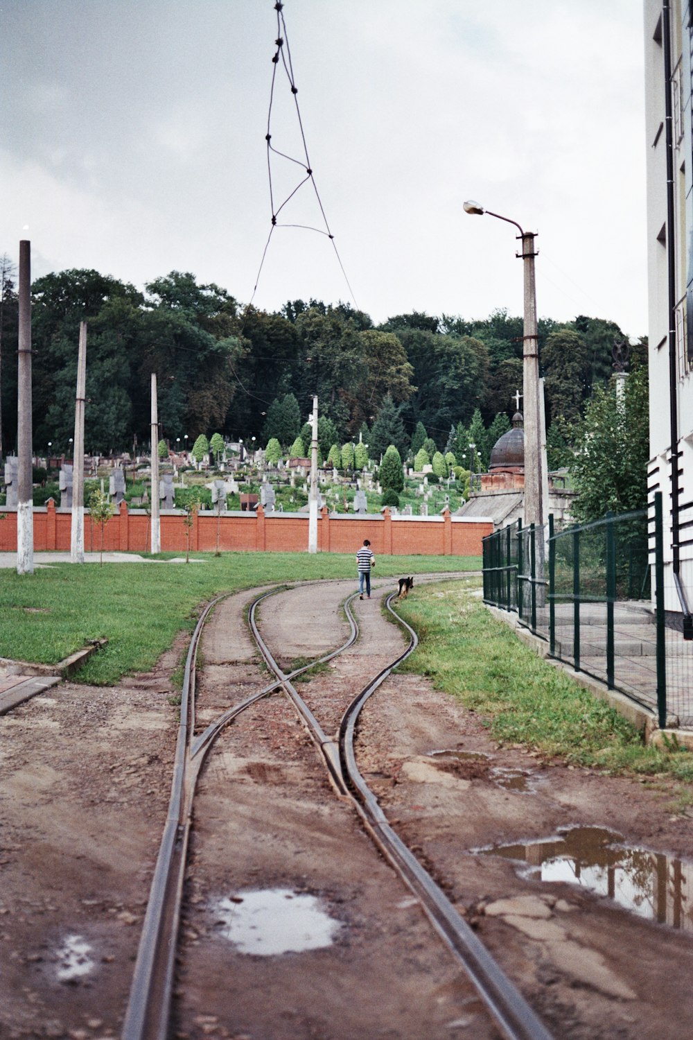 uma linha de trem com uma pessoa em pé sobre ela