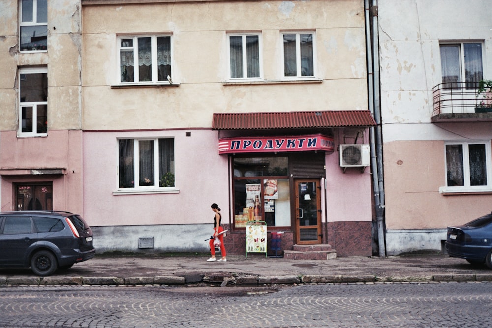 a woman standing in front of a pink building