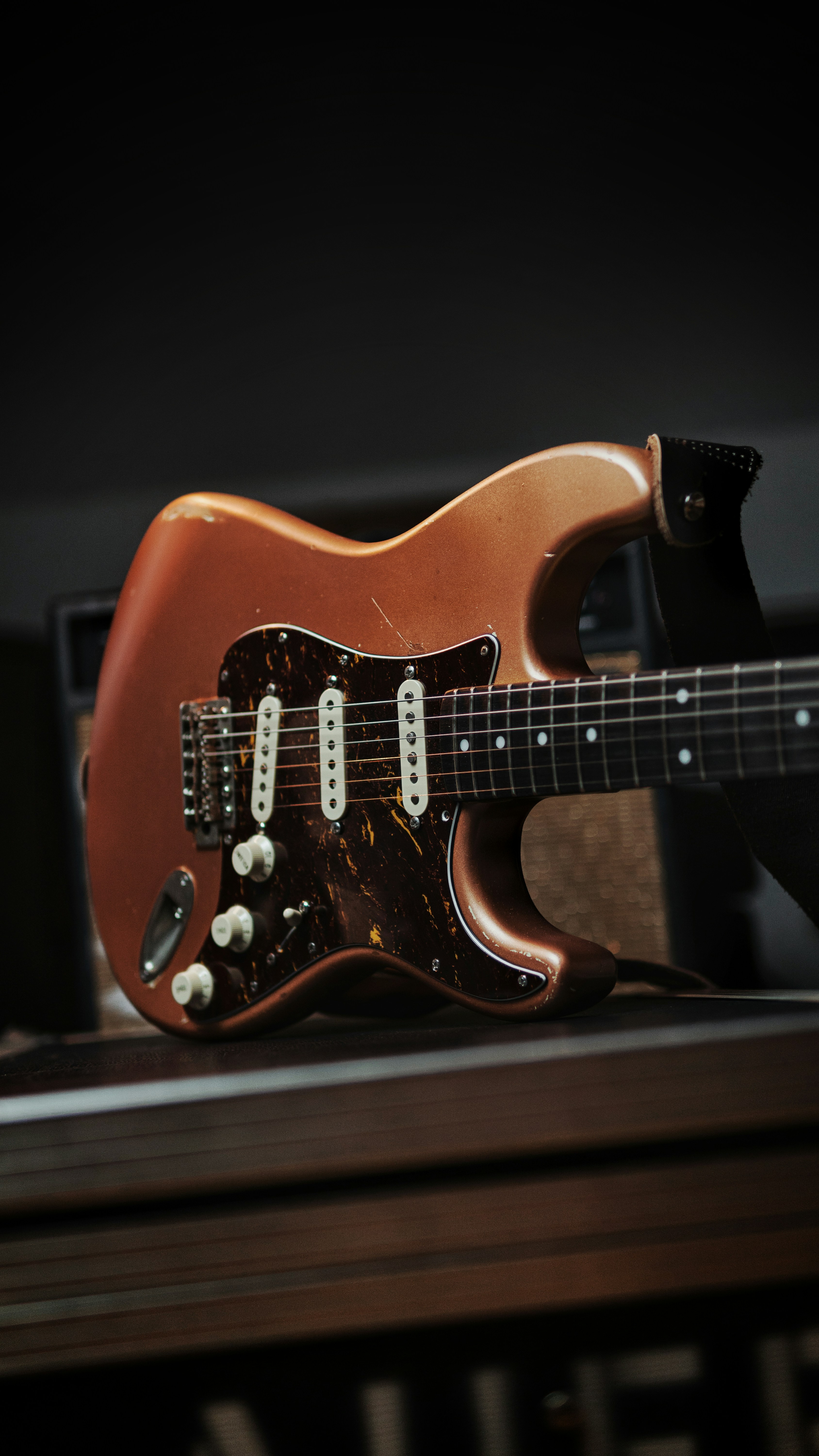 Una guitarra sentada encima de una mesa de madera