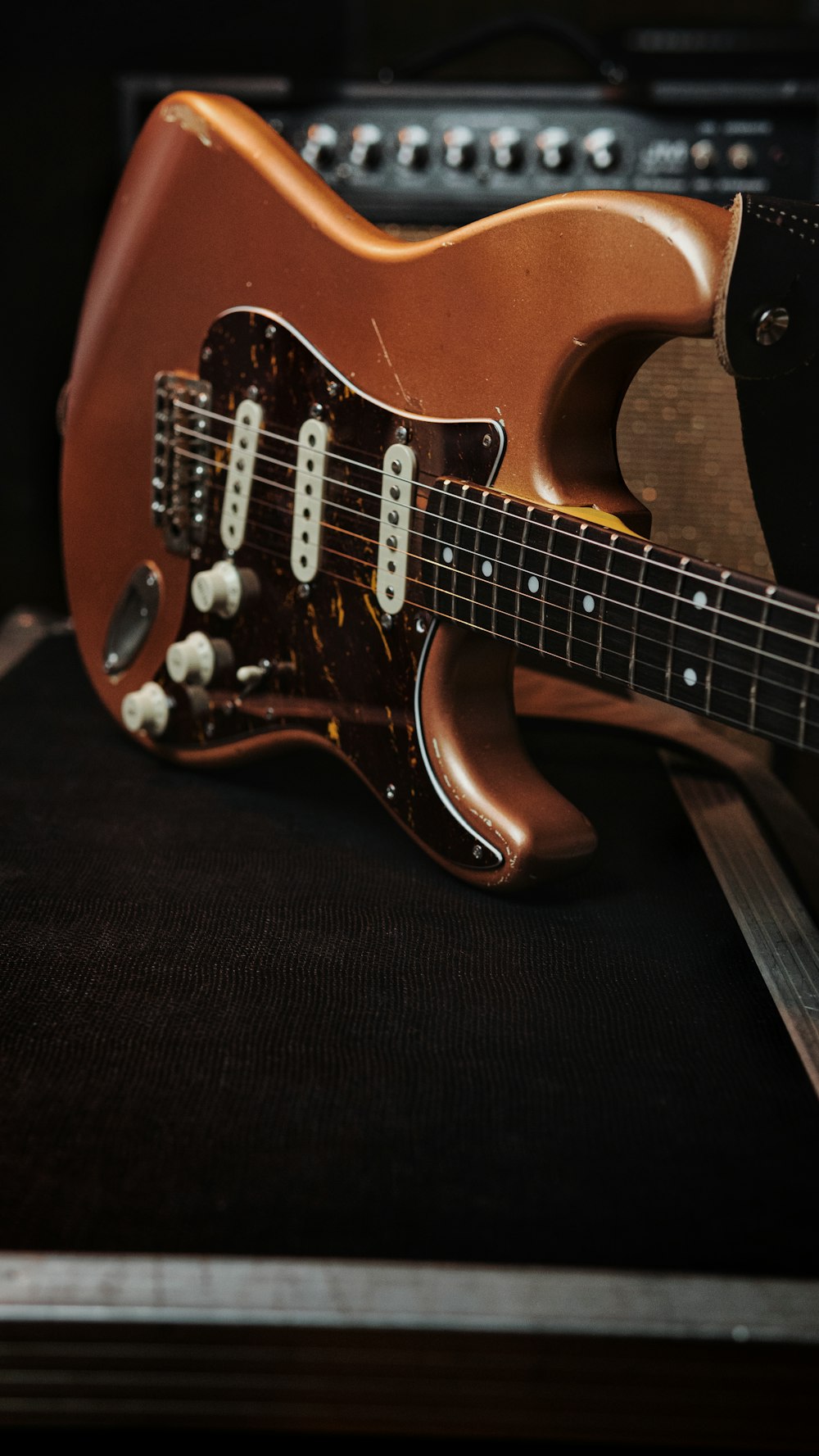 a brown electric guitar sitting on top of a table