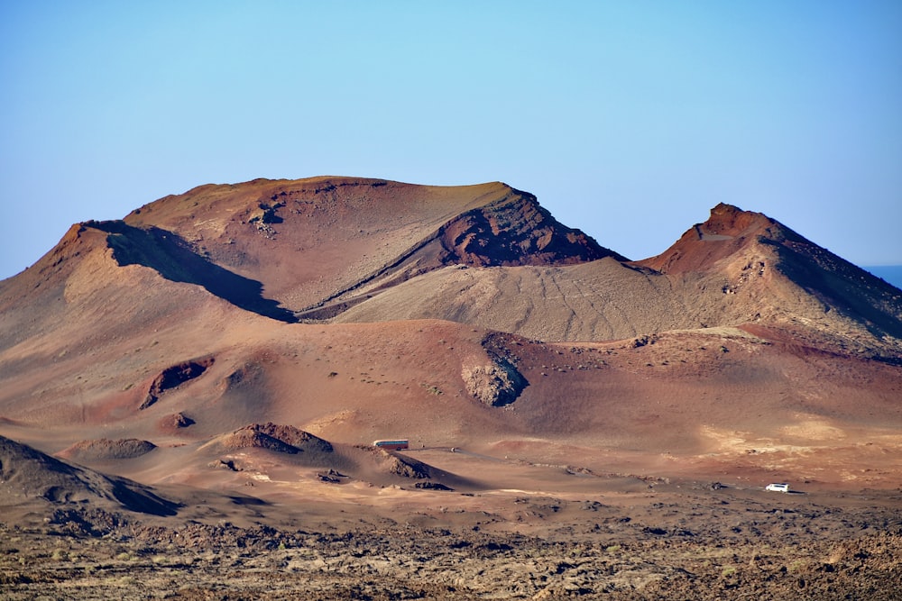 a group of mountains in the desert under a blue sky