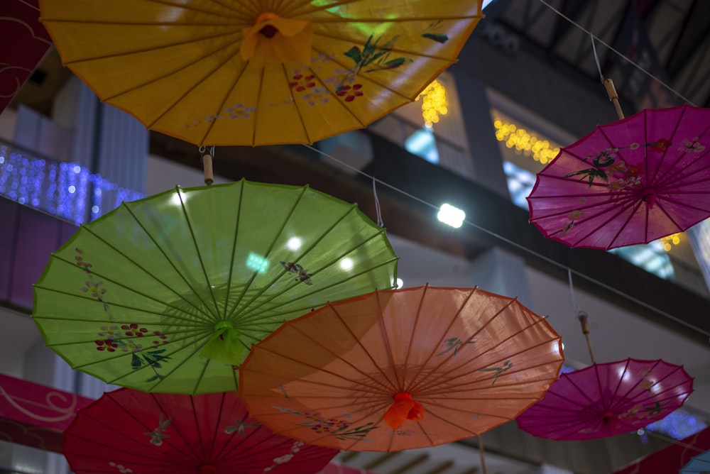 a bunch of colorful umbrellas hanging from a ceiling