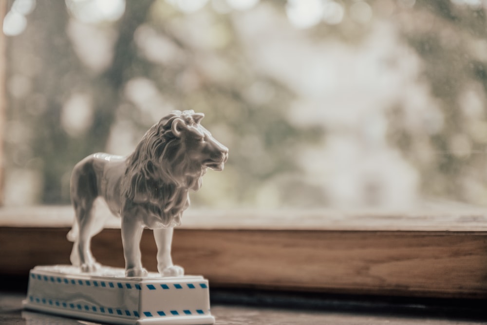 a white lion figurine sitting on top of a wooden table