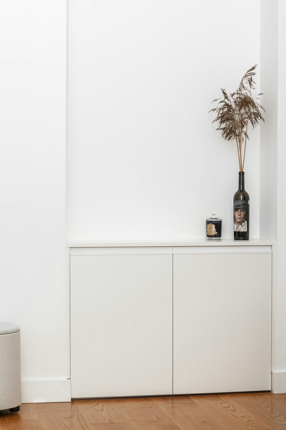 a vase with a plant on top of a white cabinet