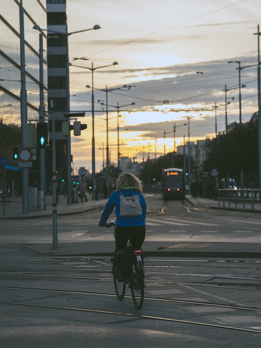 女士骑自行车穿越城市街道，体验可持续交通方式