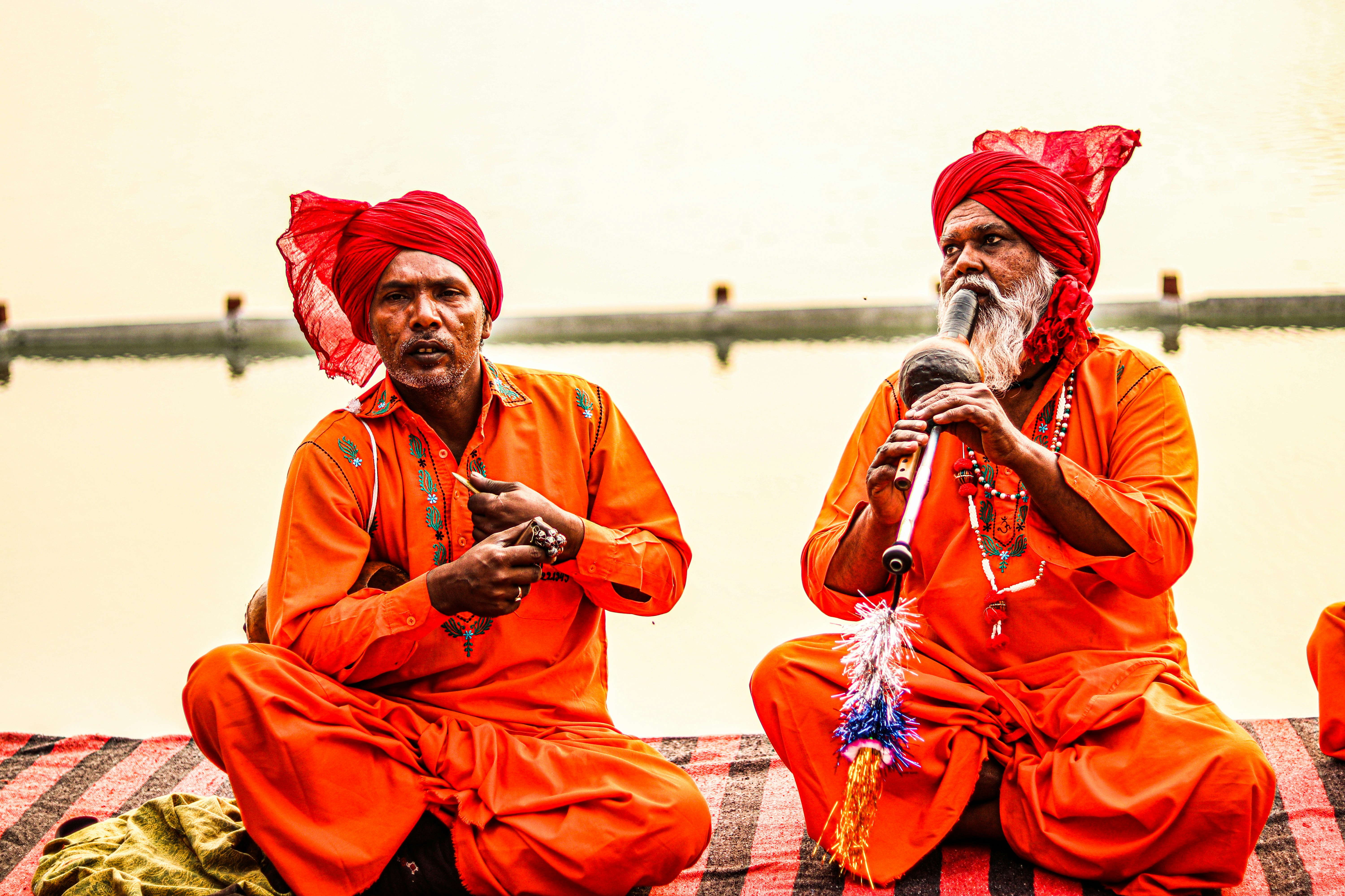 a couple of men sitting next to each other on a bed