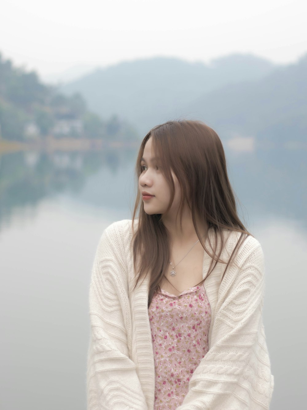 a woman standing next to a body of water