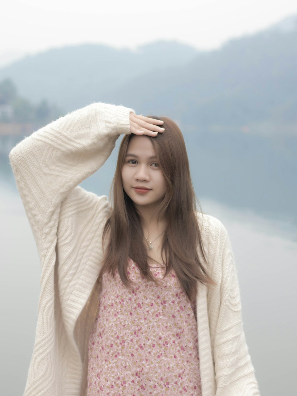 a woman standing next to a body of water