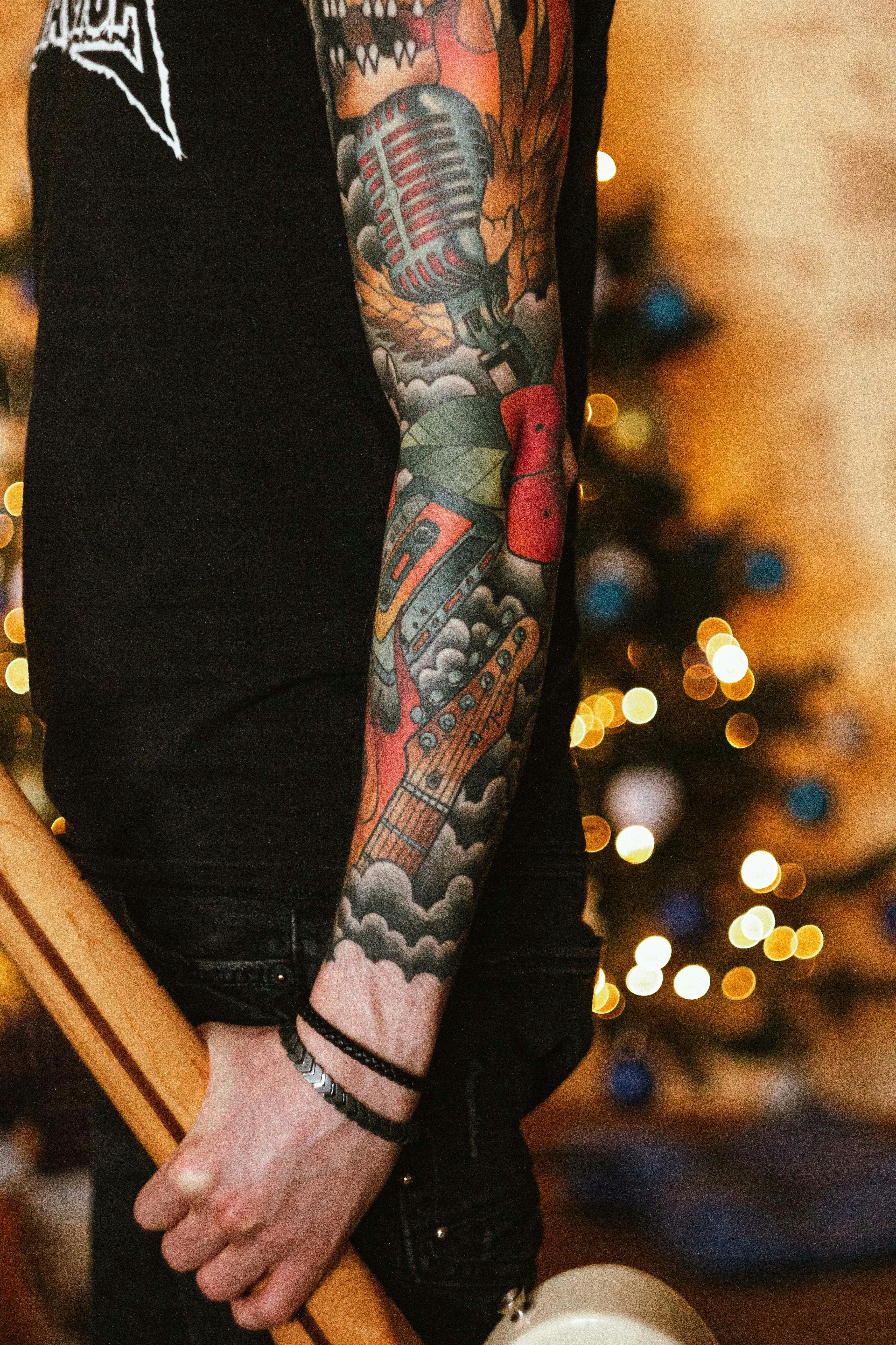 a man with a tattoo on his arm holding a baseball bat