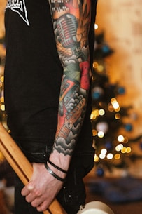 a man with a tattoo on his arm holding a baseball bat