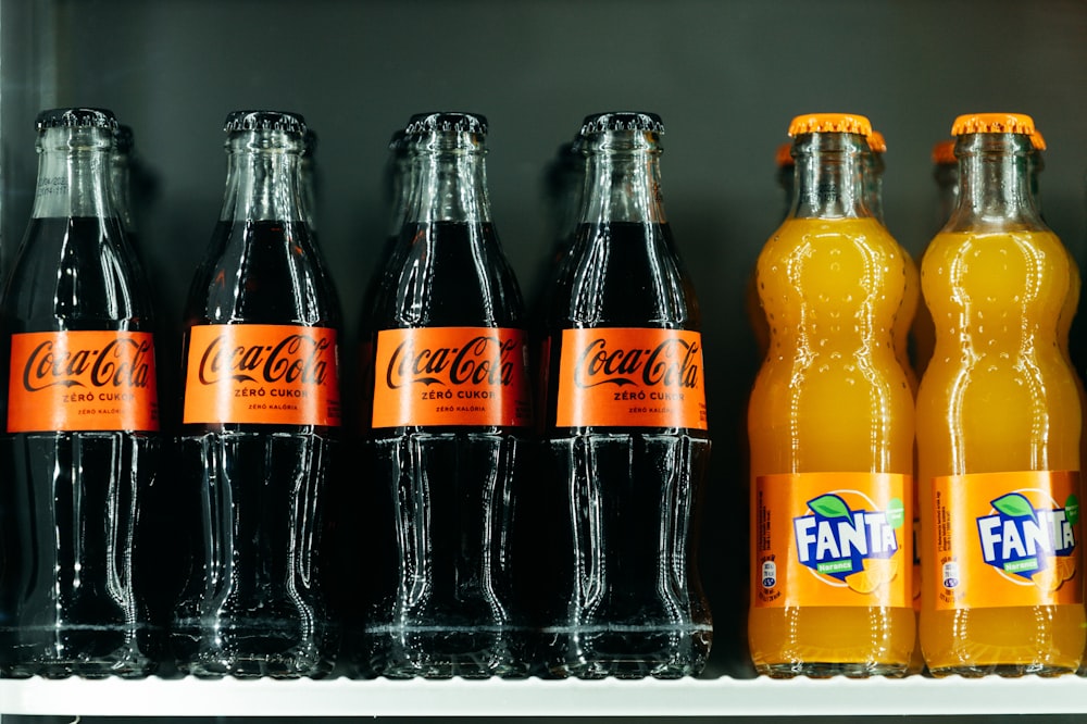 a row of soda bottles sitting on top of a shelf