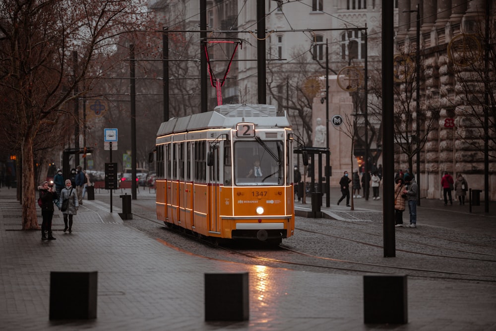 an orange trolley car on a city street