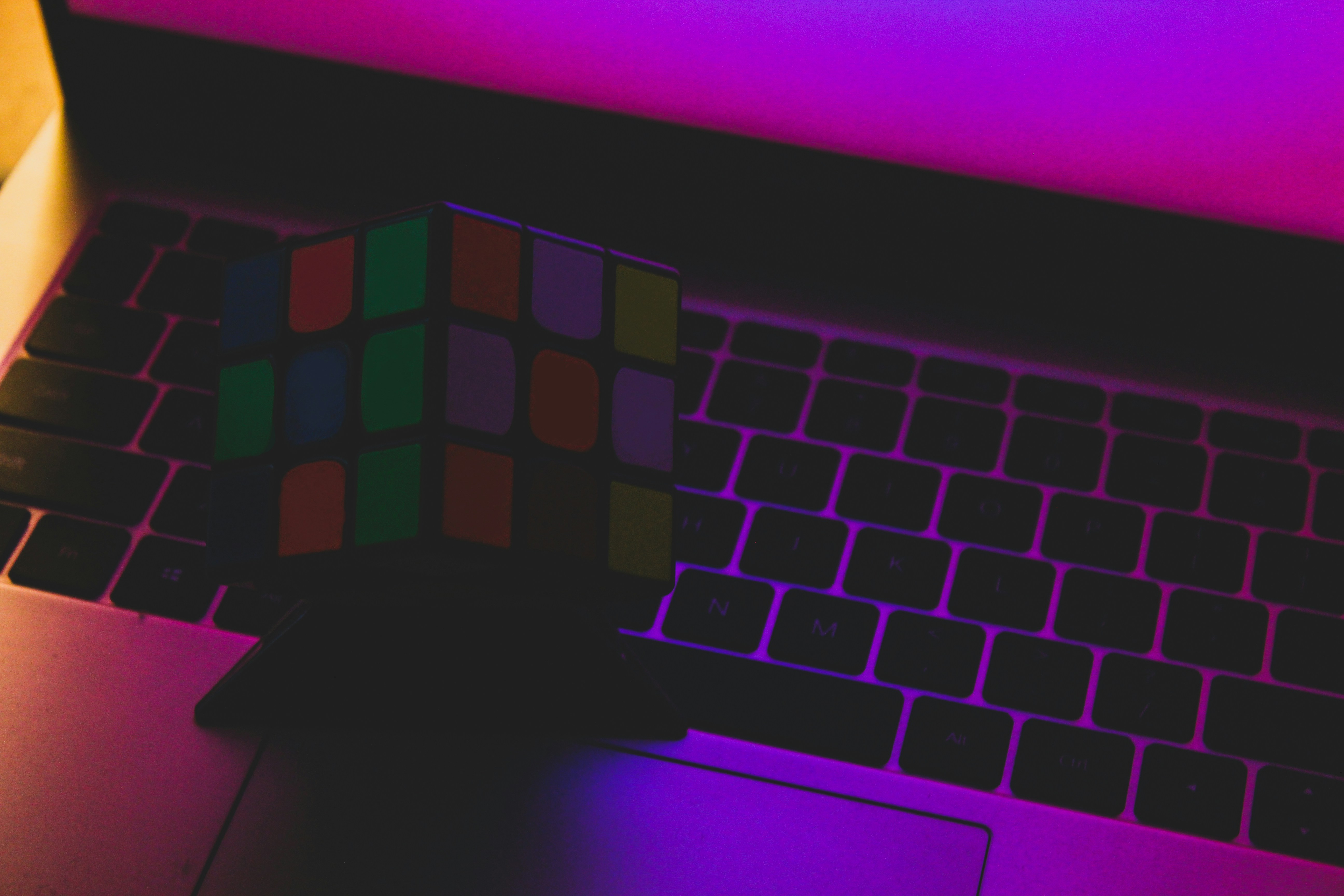 a rubik cube sitting on top of a laptop computer
