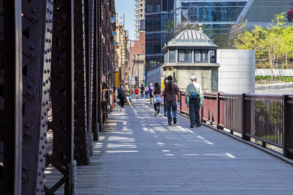 a group of people walking across a bridge