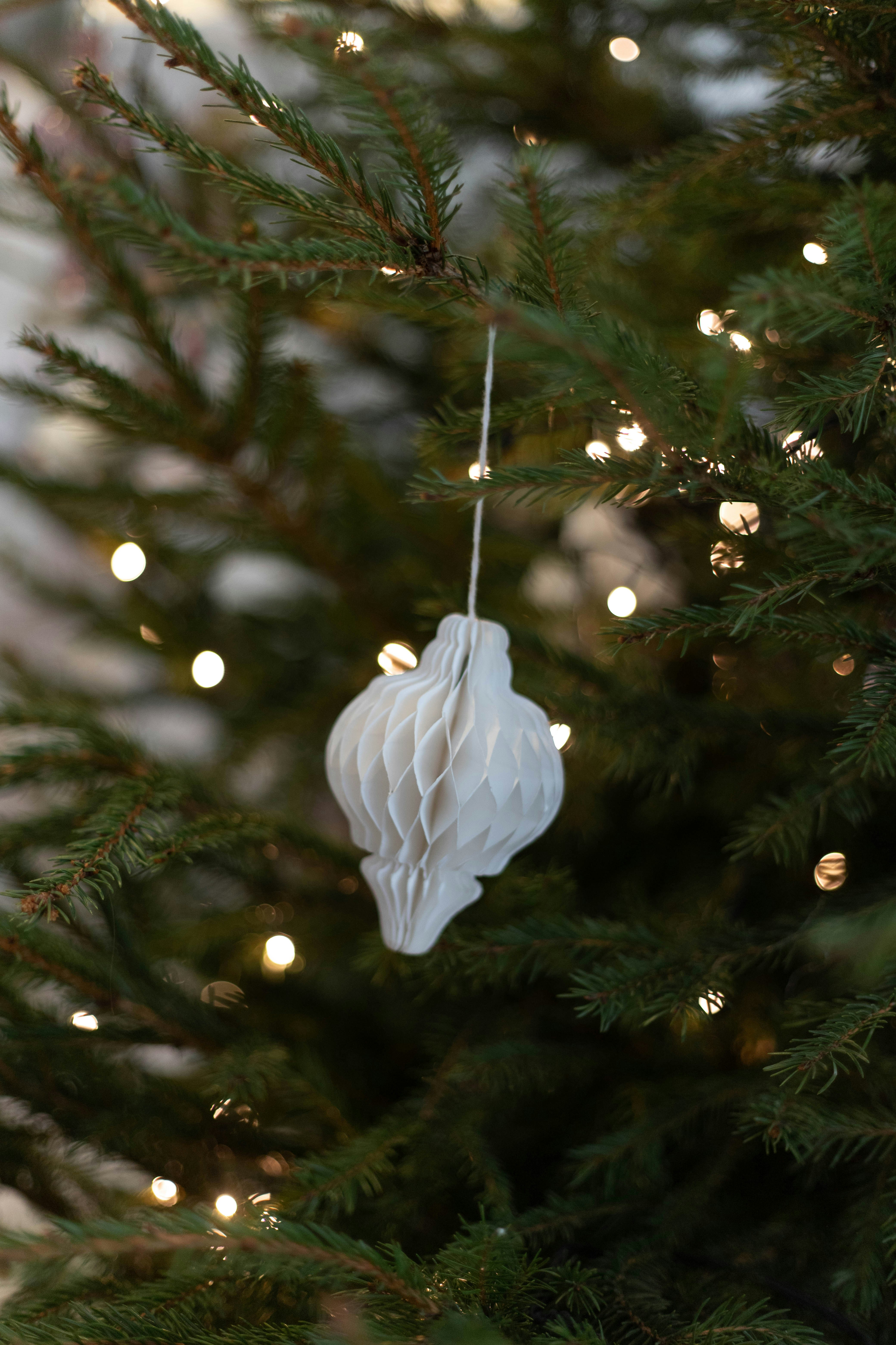 Ein weißes Ornament, das an einem Weihnachtsbaum hängt