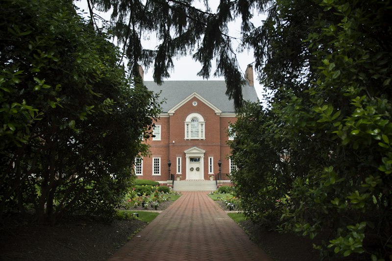 A traditional brick home framed by mature greenery, illustrating Yalecrest’s residential character