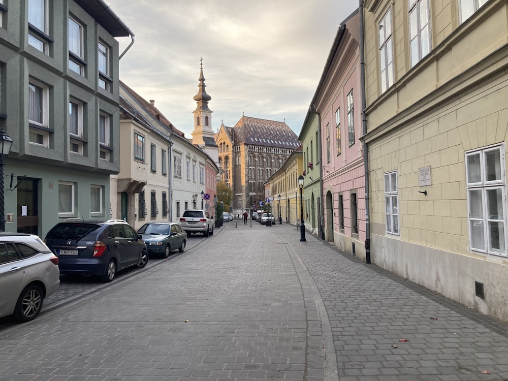 Une rue bordée de voitures garées à côté de grands immeubles