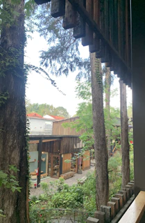 A peaceful outdoor meditation space surrounded by lush greenery and wooden accents.