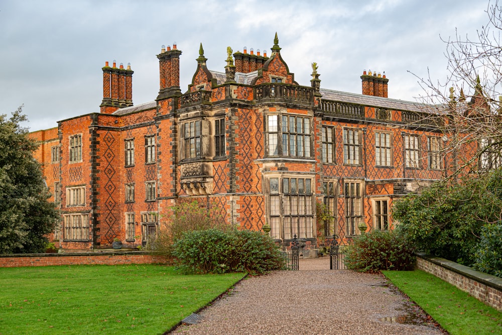 a large brick building sitting on top of a lush green field