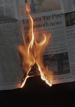 a newspaper with a fire burning in the middle of it