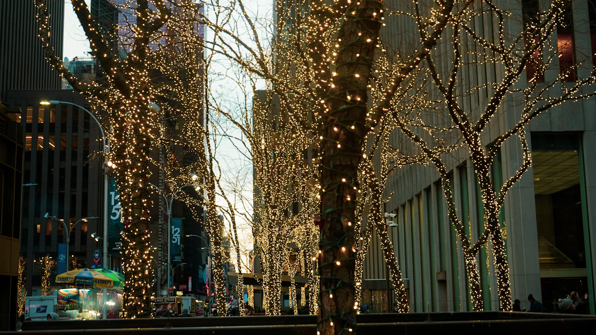 Trees wrapped in warm white fairy lights along a New York street at dusk