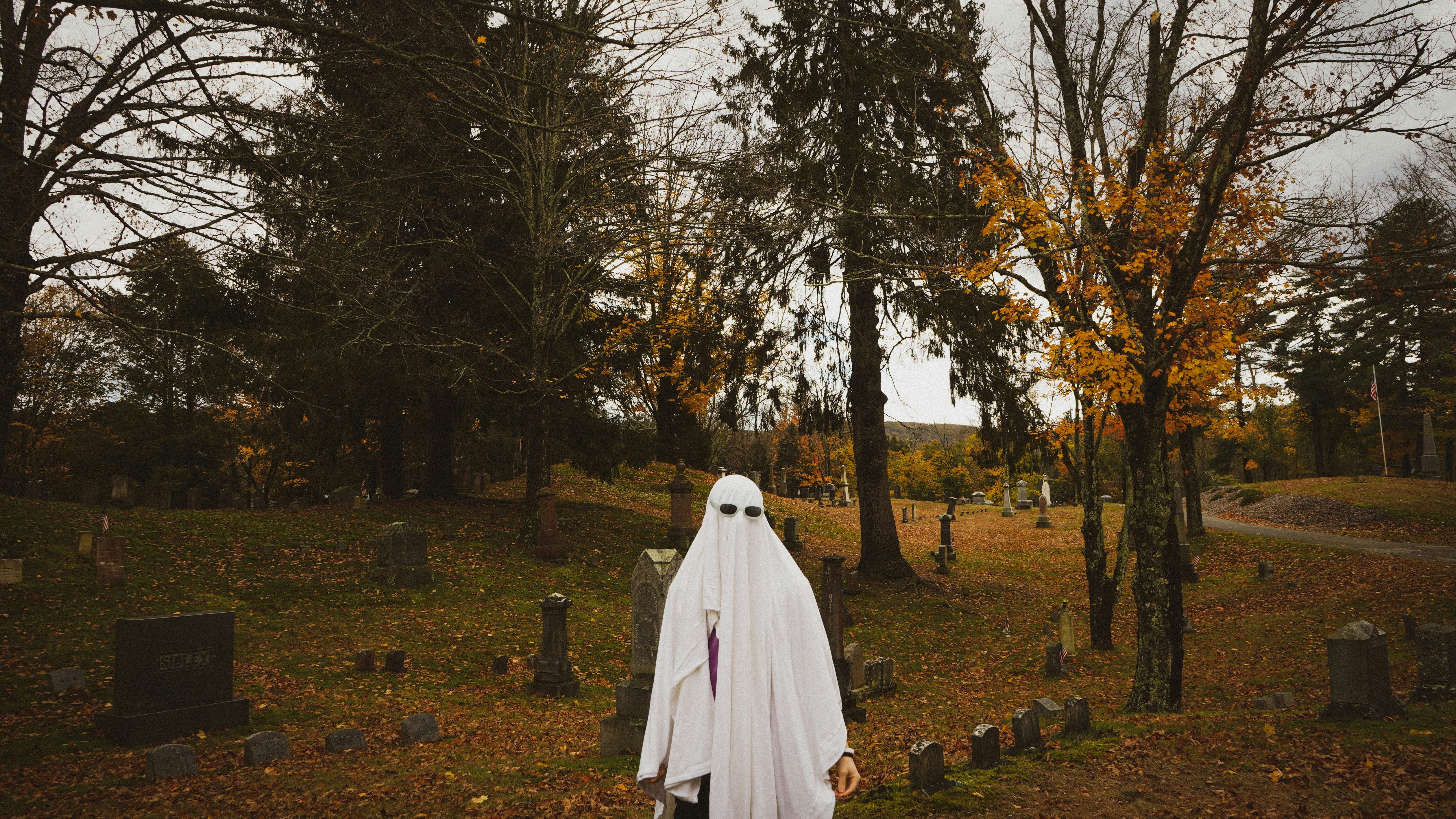 ghost in sunglasses visiting graveyard on halloween, oct 2021