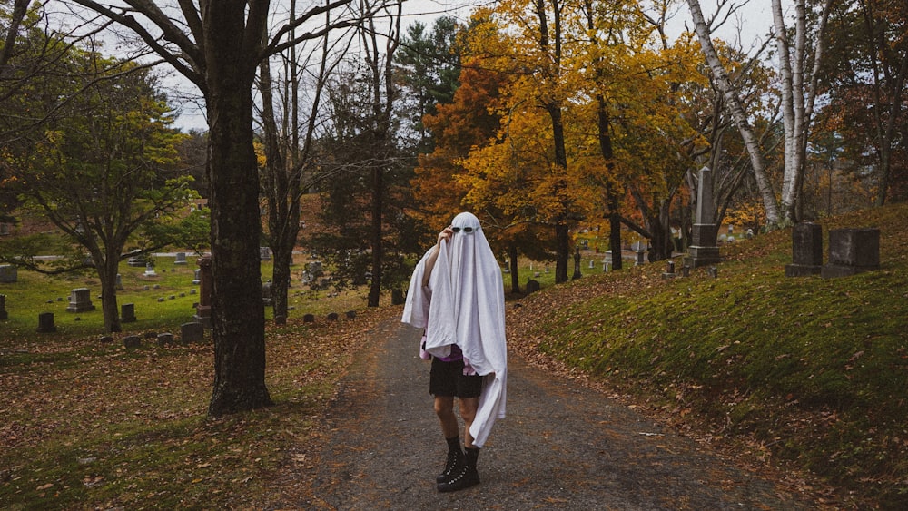 a person dressed as a ghost walking down a road