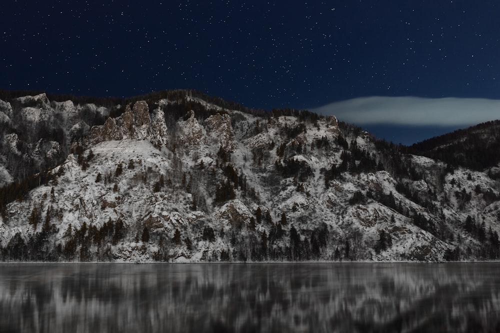 a snowy mountain with a lake in front of it