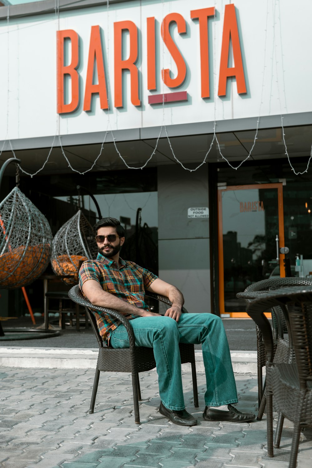 a man sitting in a chair in front of a store