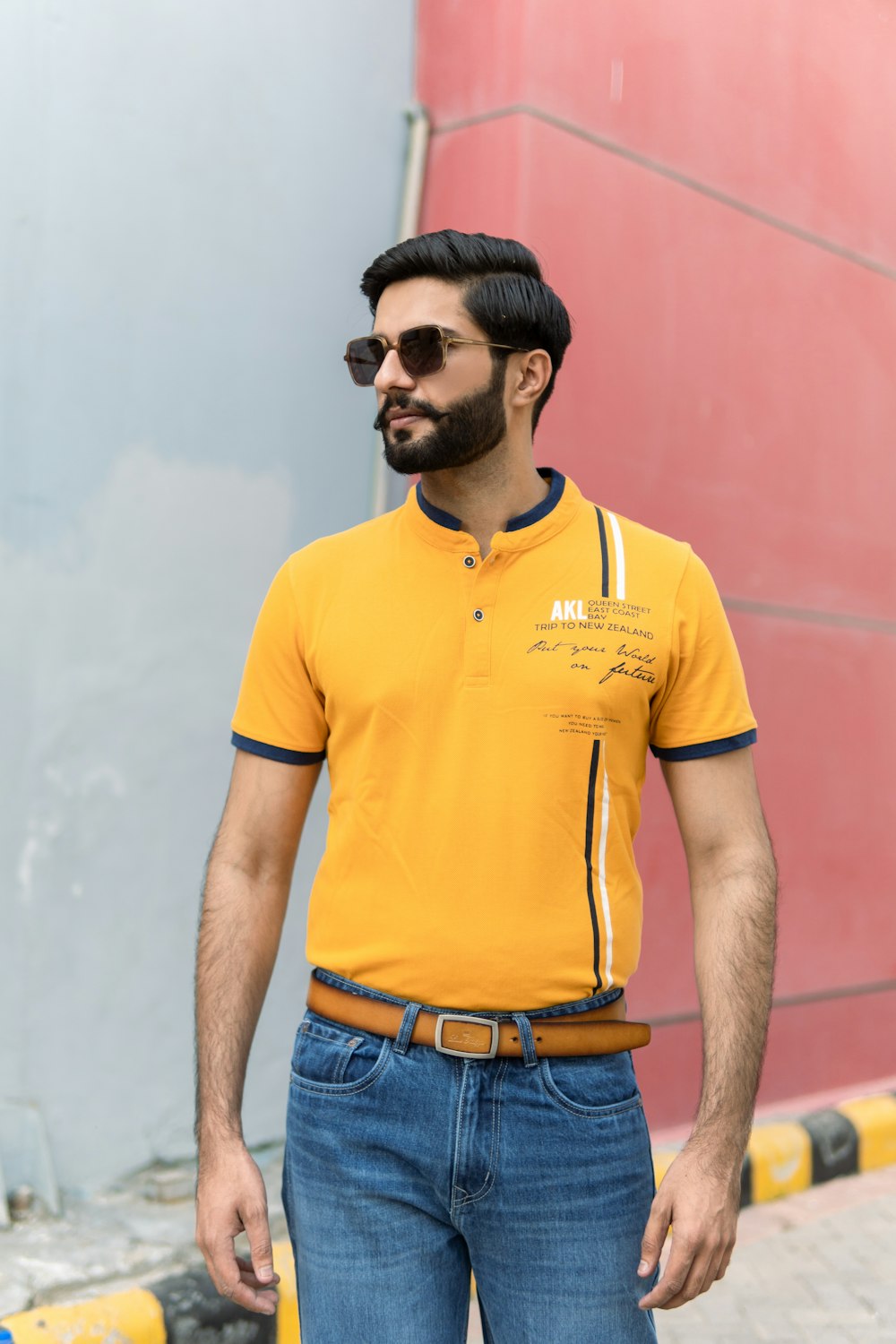 a man wearing a yellow polo shirt and jeans