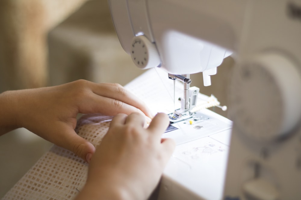 a close up of a person using a sewing machine